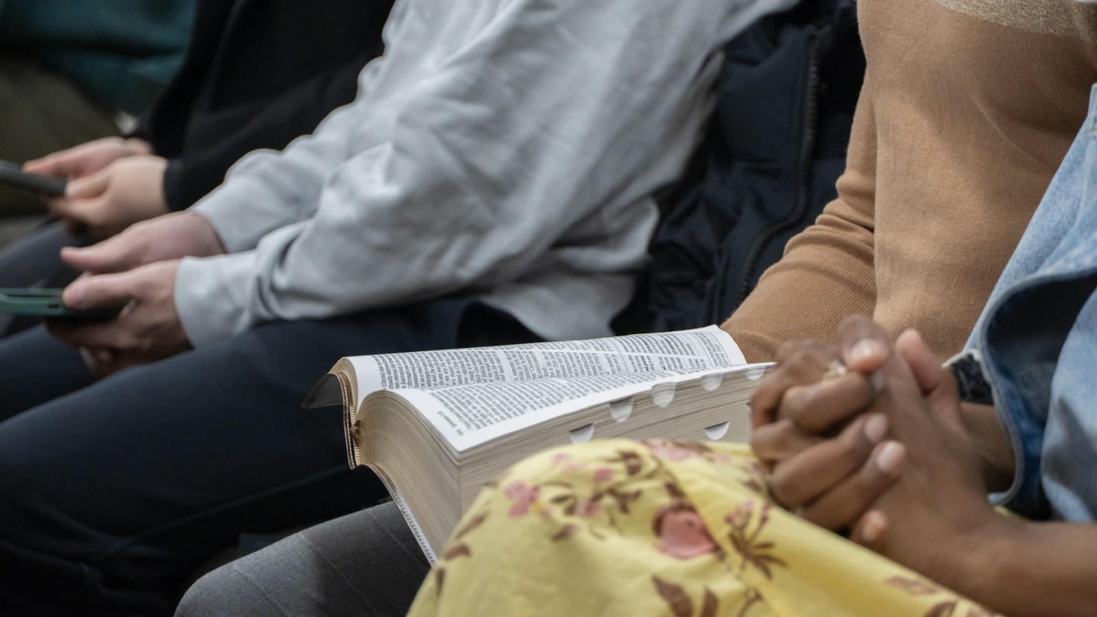 Personas reunidas en oración y lectura bíblica